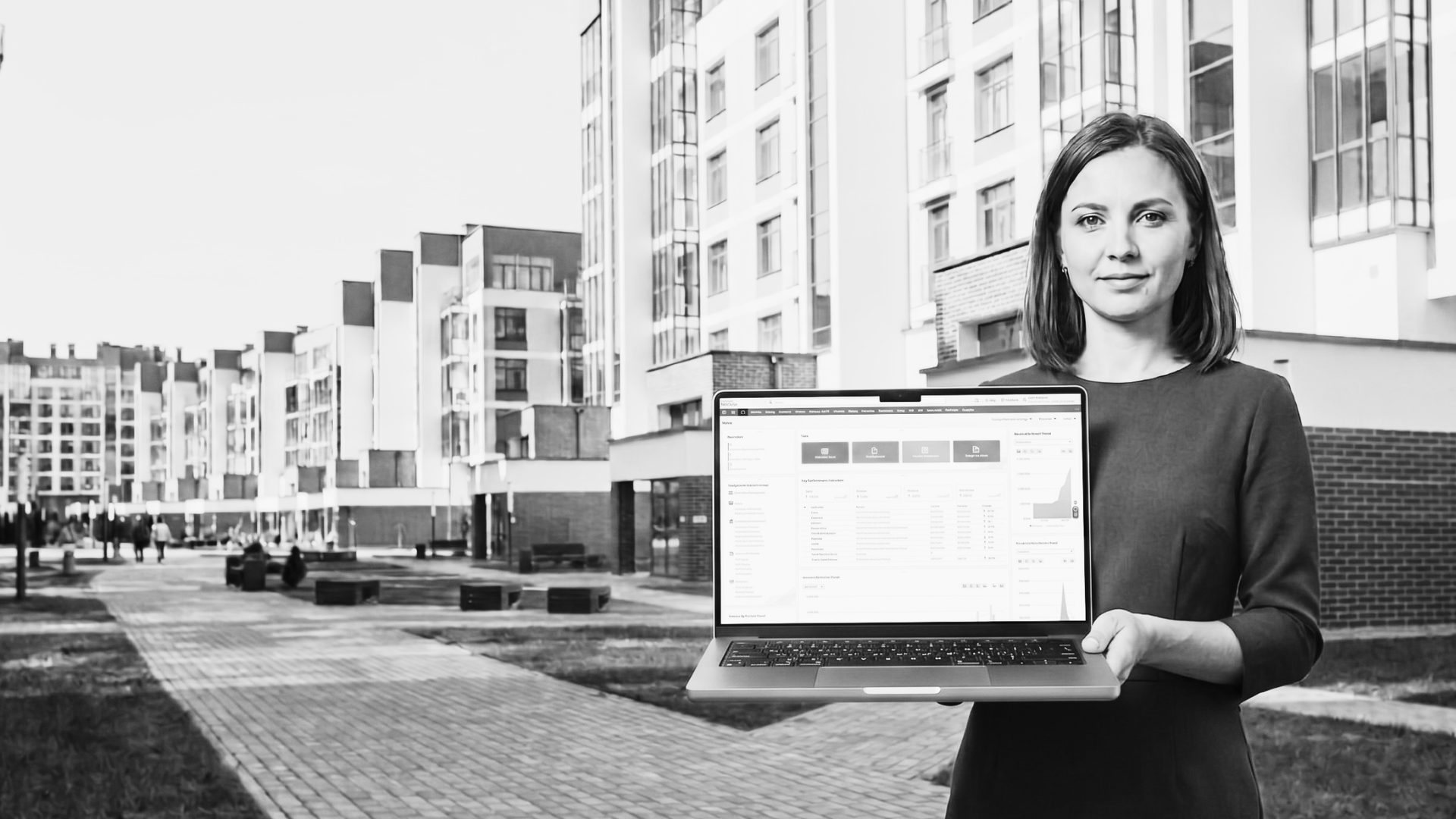 Asesora inmobiliaria mostrando el dashboard de NetSuite frente a un desarrollo